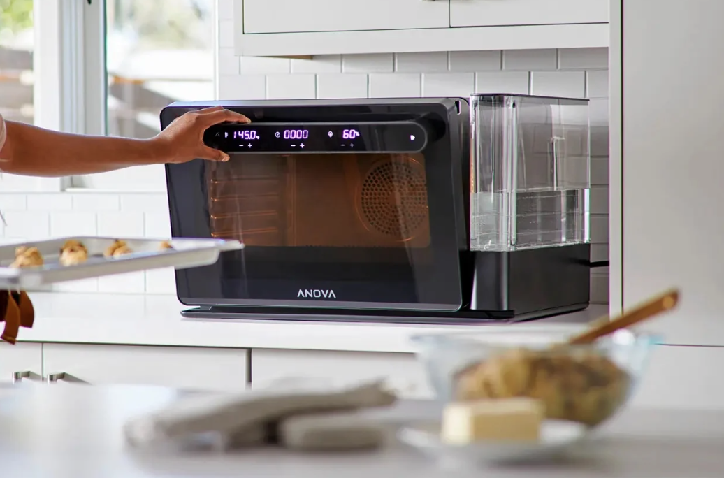 Hand opening the door of a combi oven.