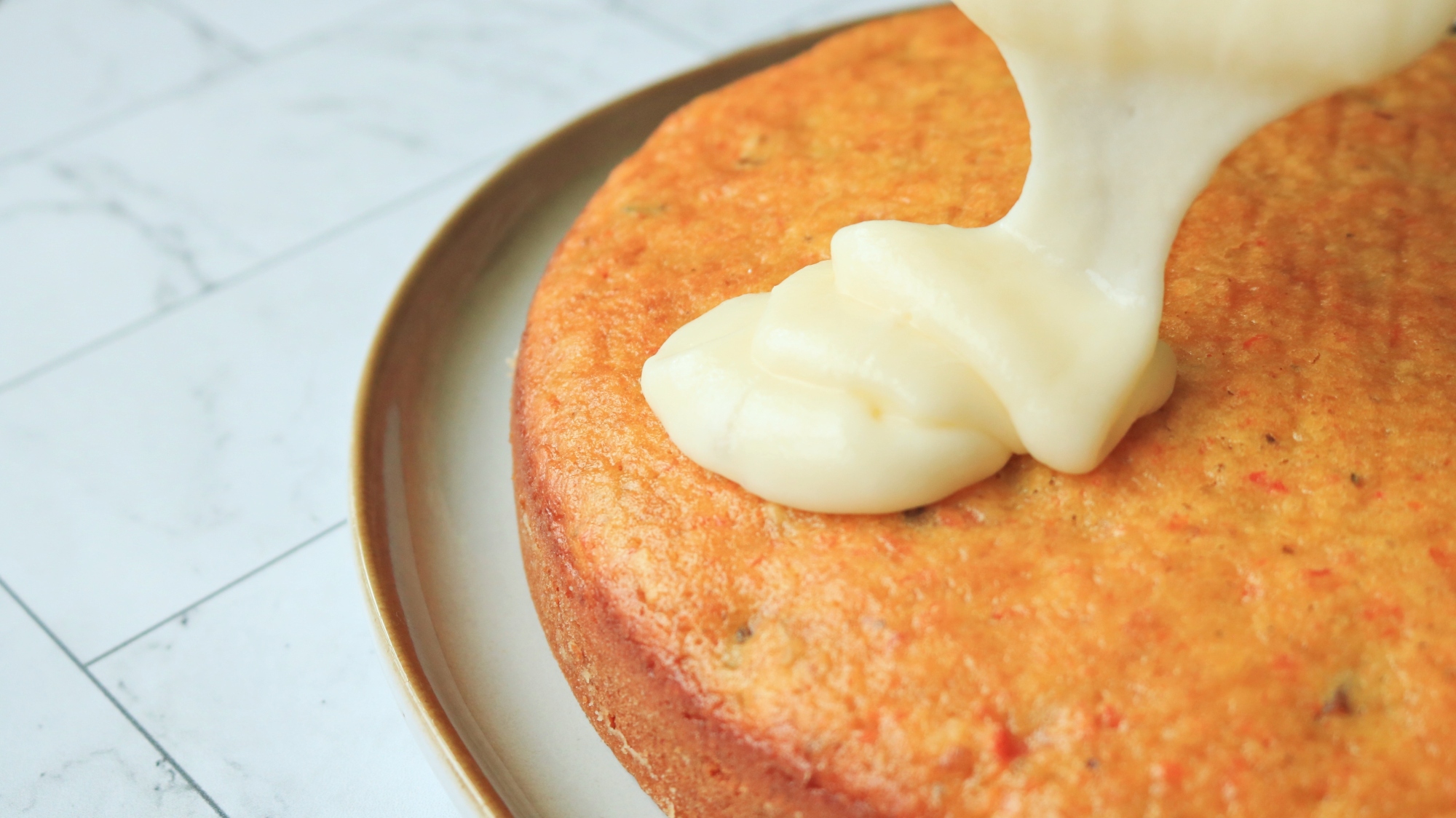 Cream cheese icing dribbling onto a cake