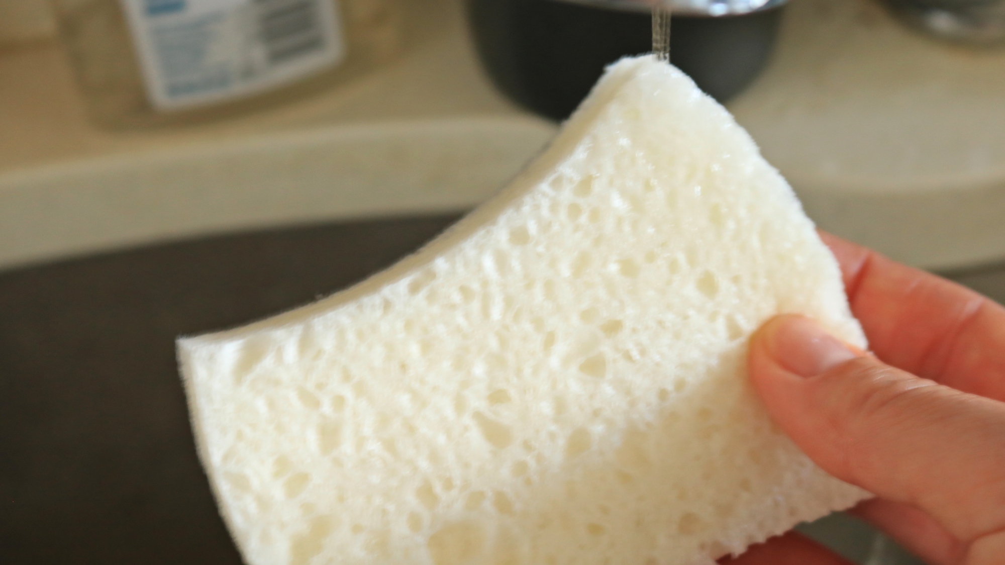 Water running onto a dish sponge.